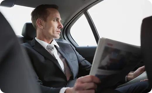 Executive reading newspaper in Florida luxury car service